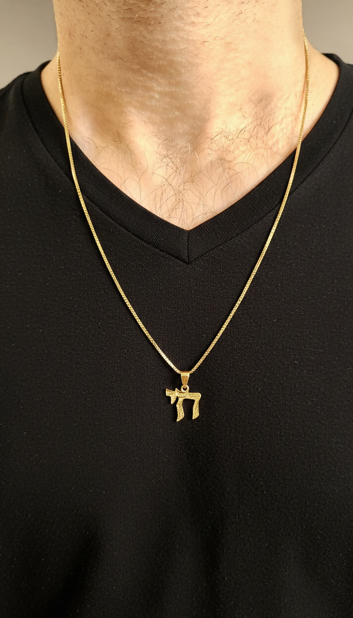 Gold necklace with a pendant on a black shirt