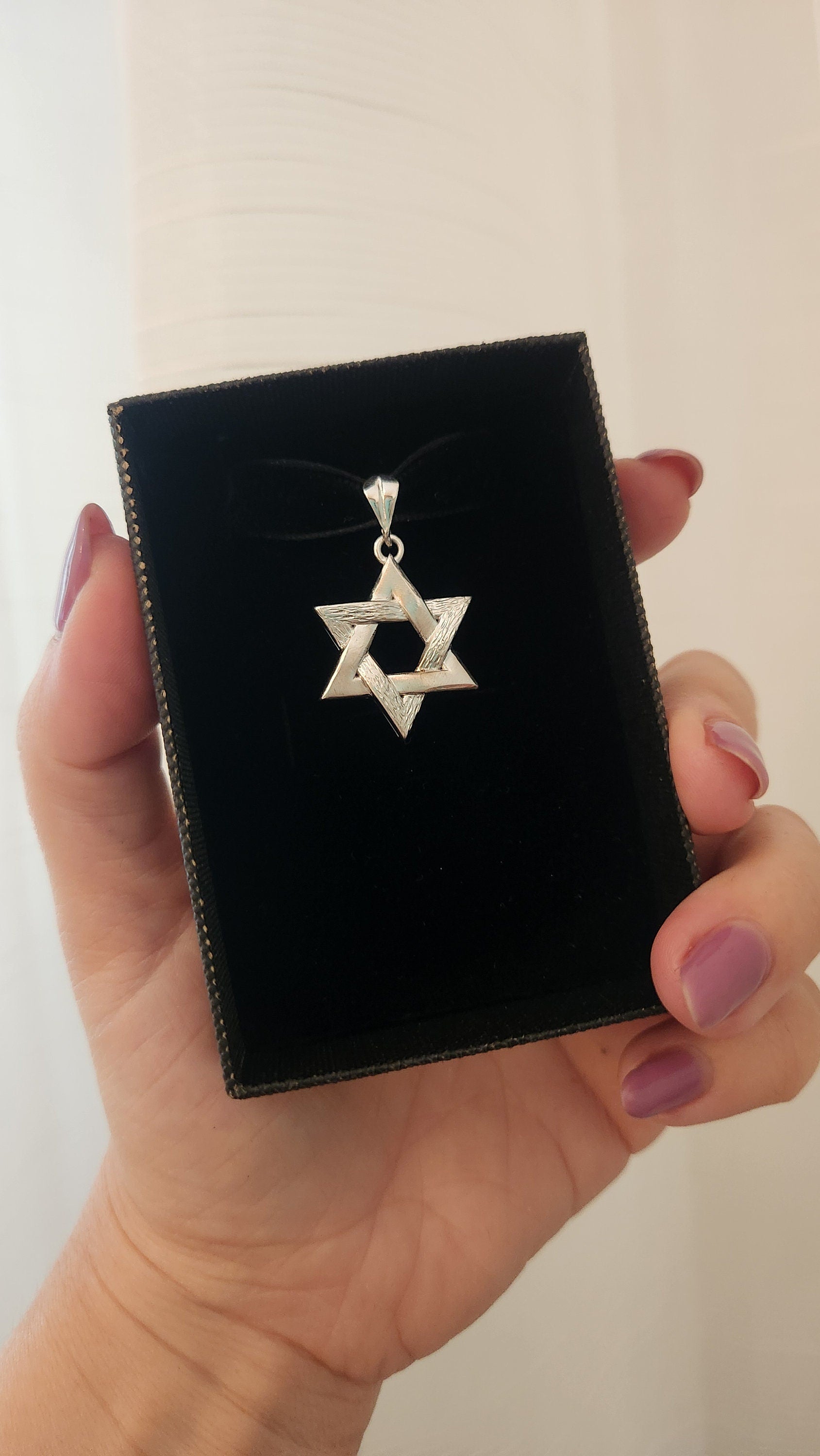 a person holding a black box with a star of david on it